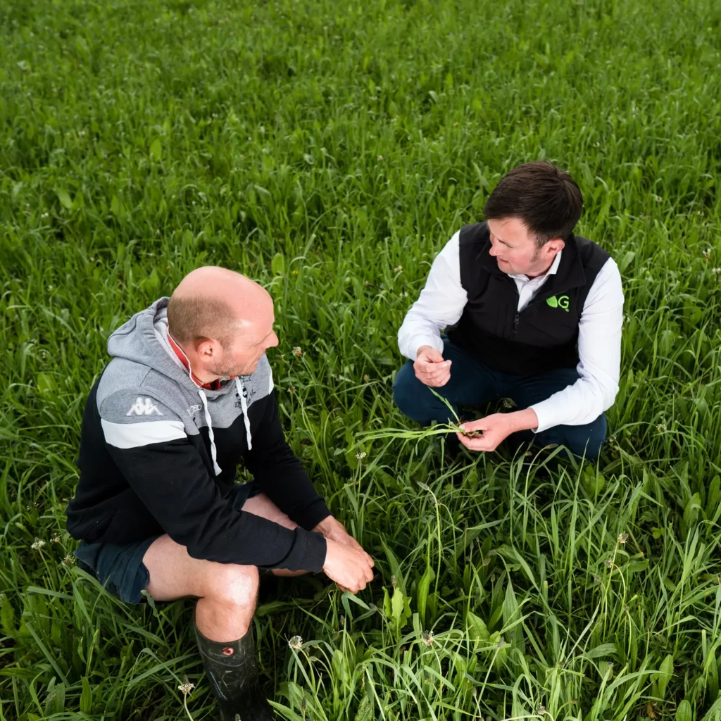 Germinal expert Harley Brown-Keech crouching in a field with a Welsh farmer