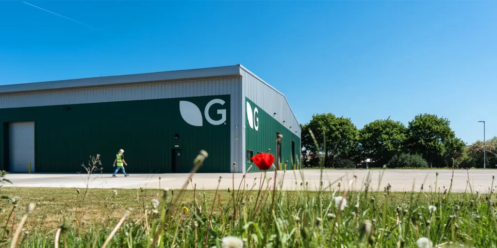 An image of a Germinal warehouse, with green grass and blue sky,